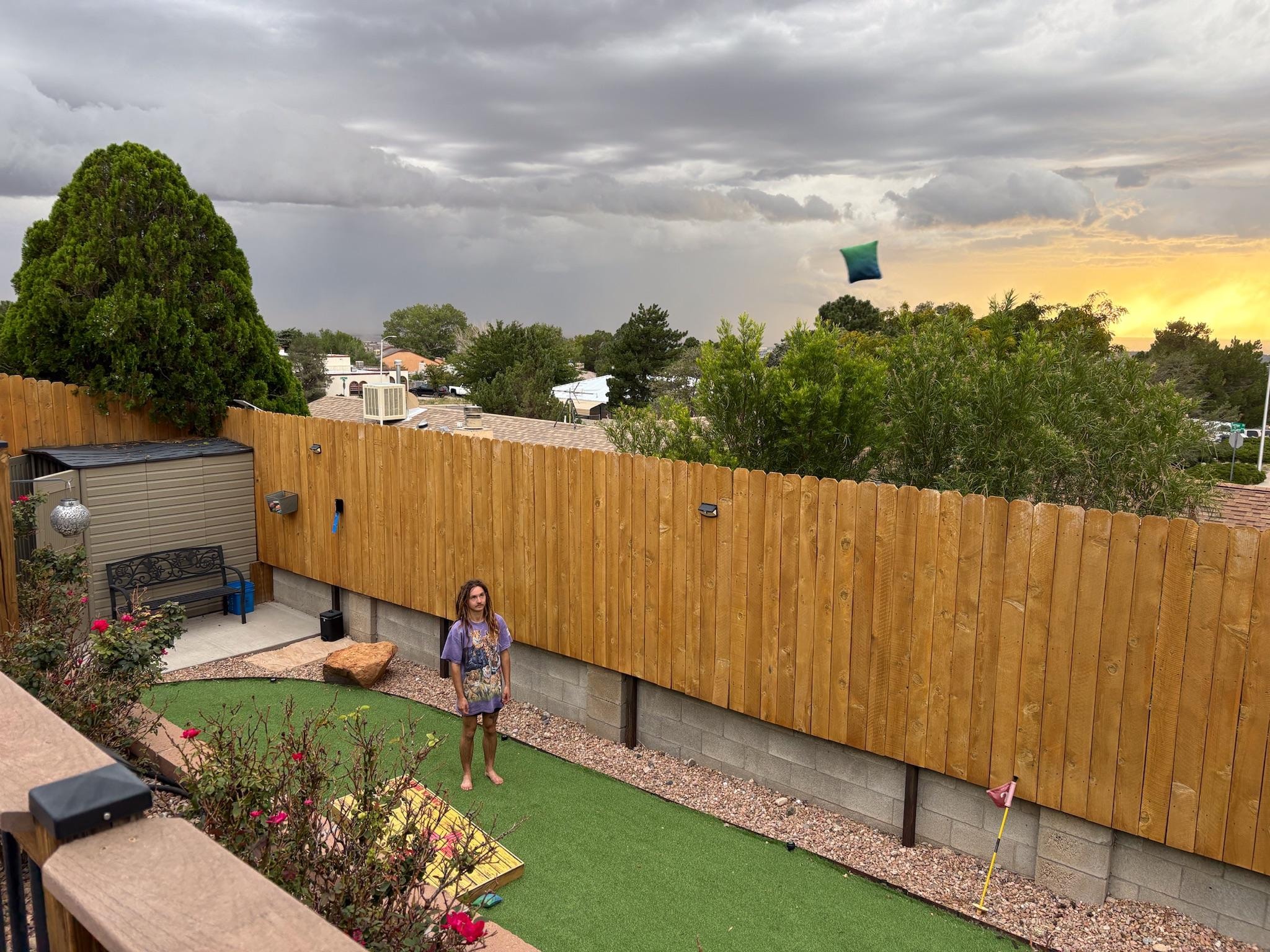 Corn hole on top of the green in the backyard. You can see in the sky there is a sack being thrown. lol 
