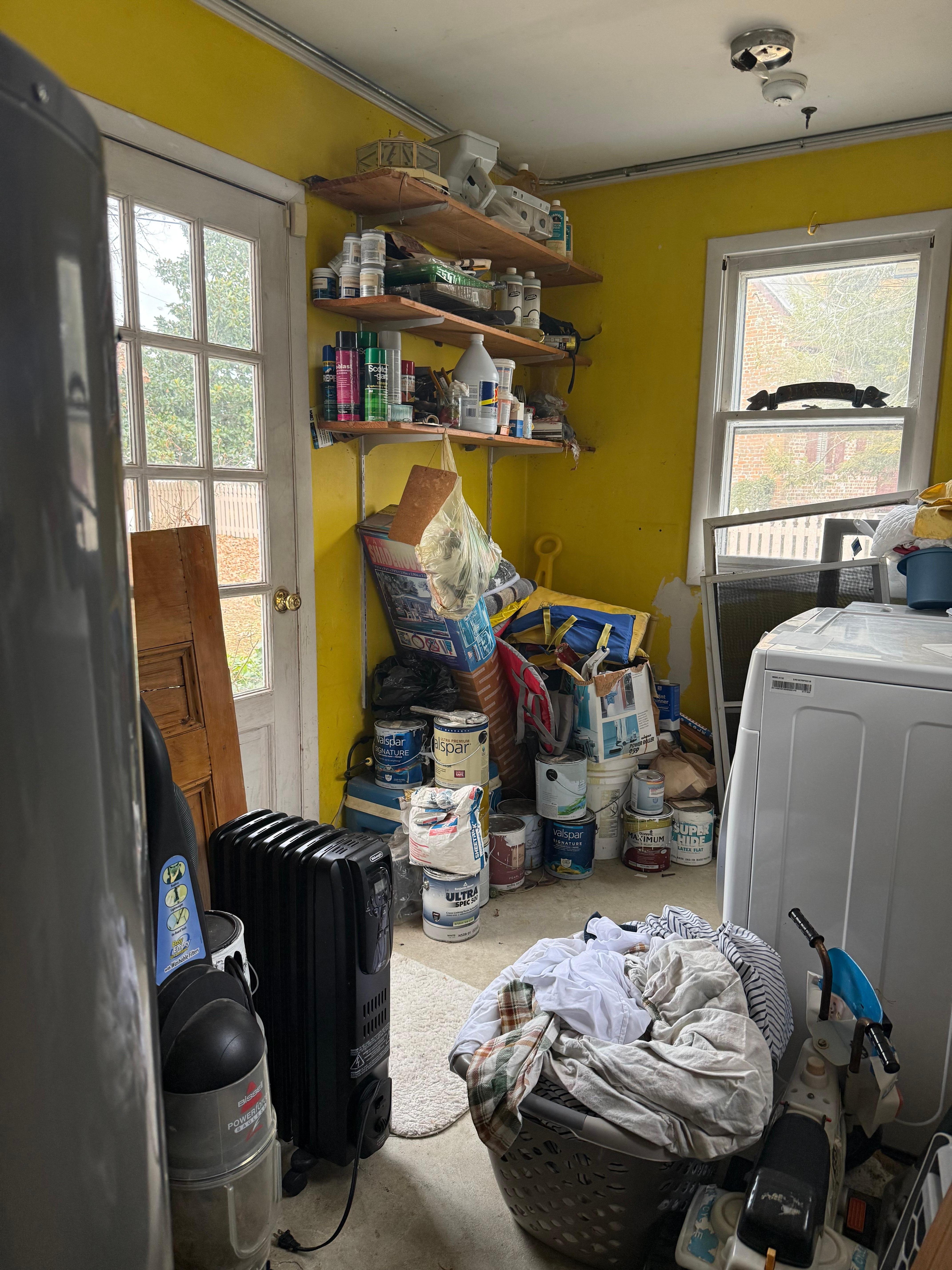 the "laundry room" completely full with a dirty basket of bedding and owner's belongings.