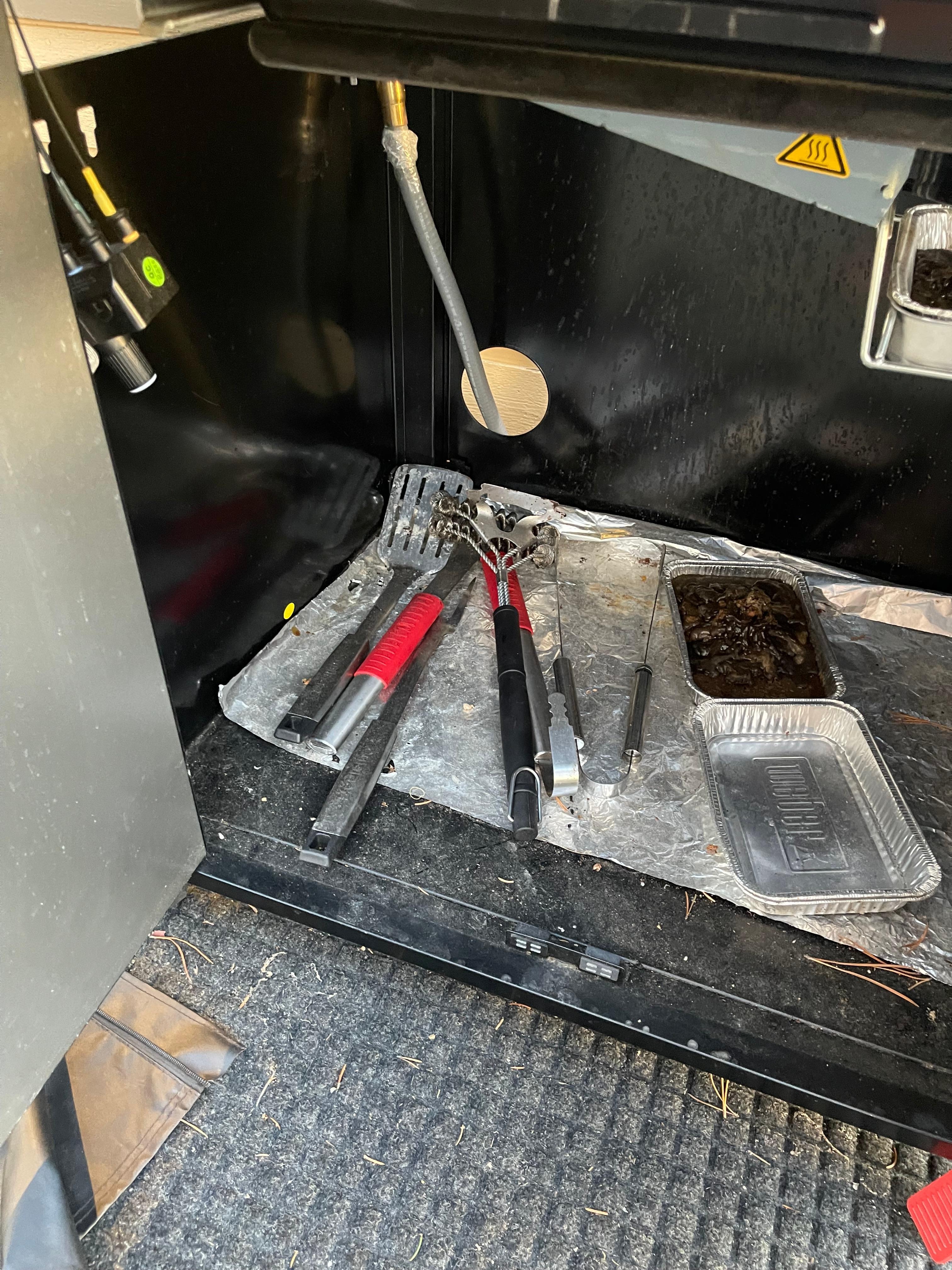 Grill was left uncovered with dirty utensils 
