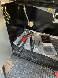 Grill was left uncovered with dirty utensils