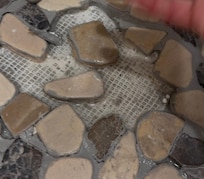 Spot to left of drain in shower loose rocks