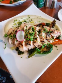 The roasted chicken with creamy mashed potatoes and greens with a mushroom sauce.