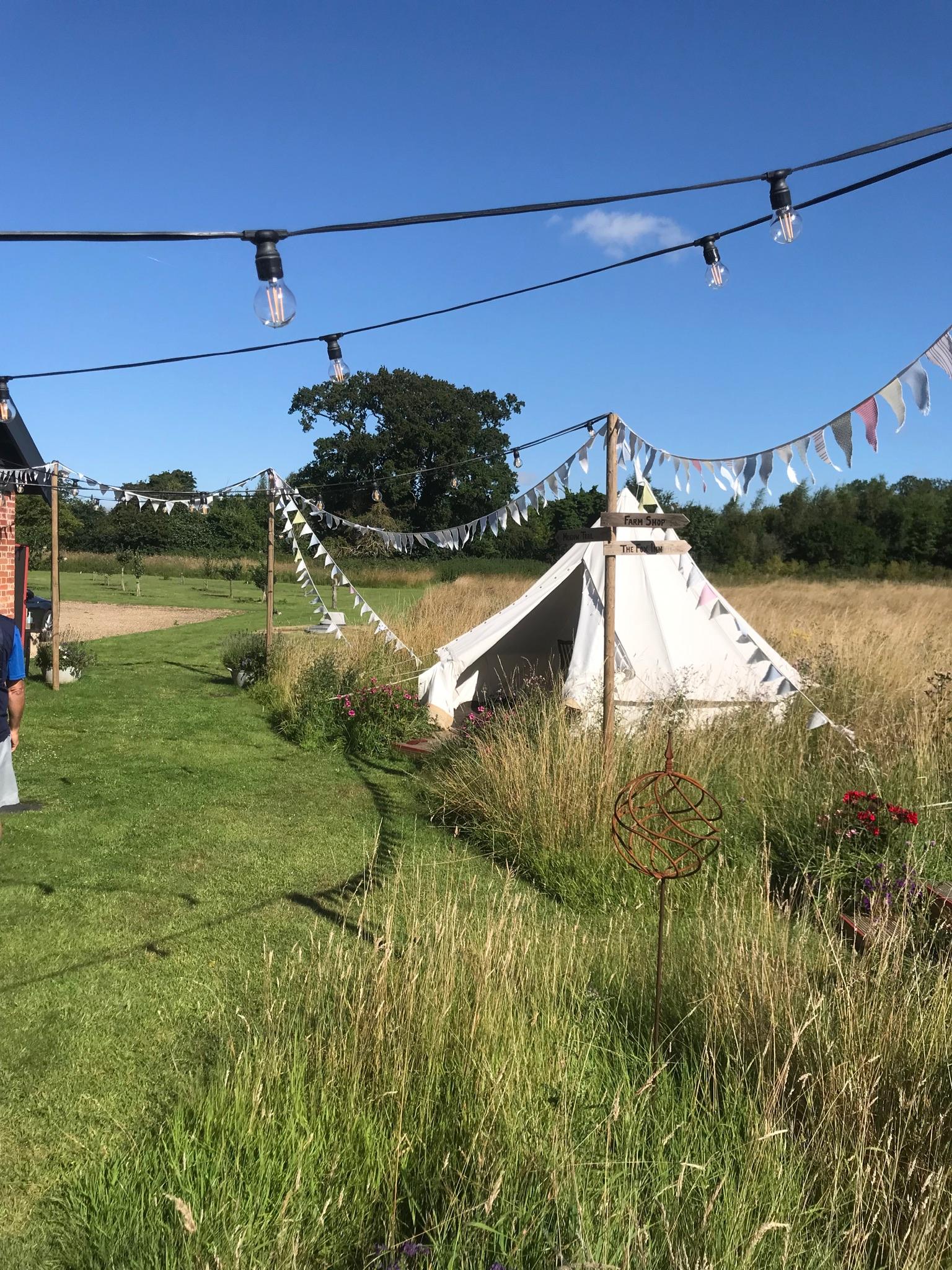 View of one of the teepees and meadow beyond.