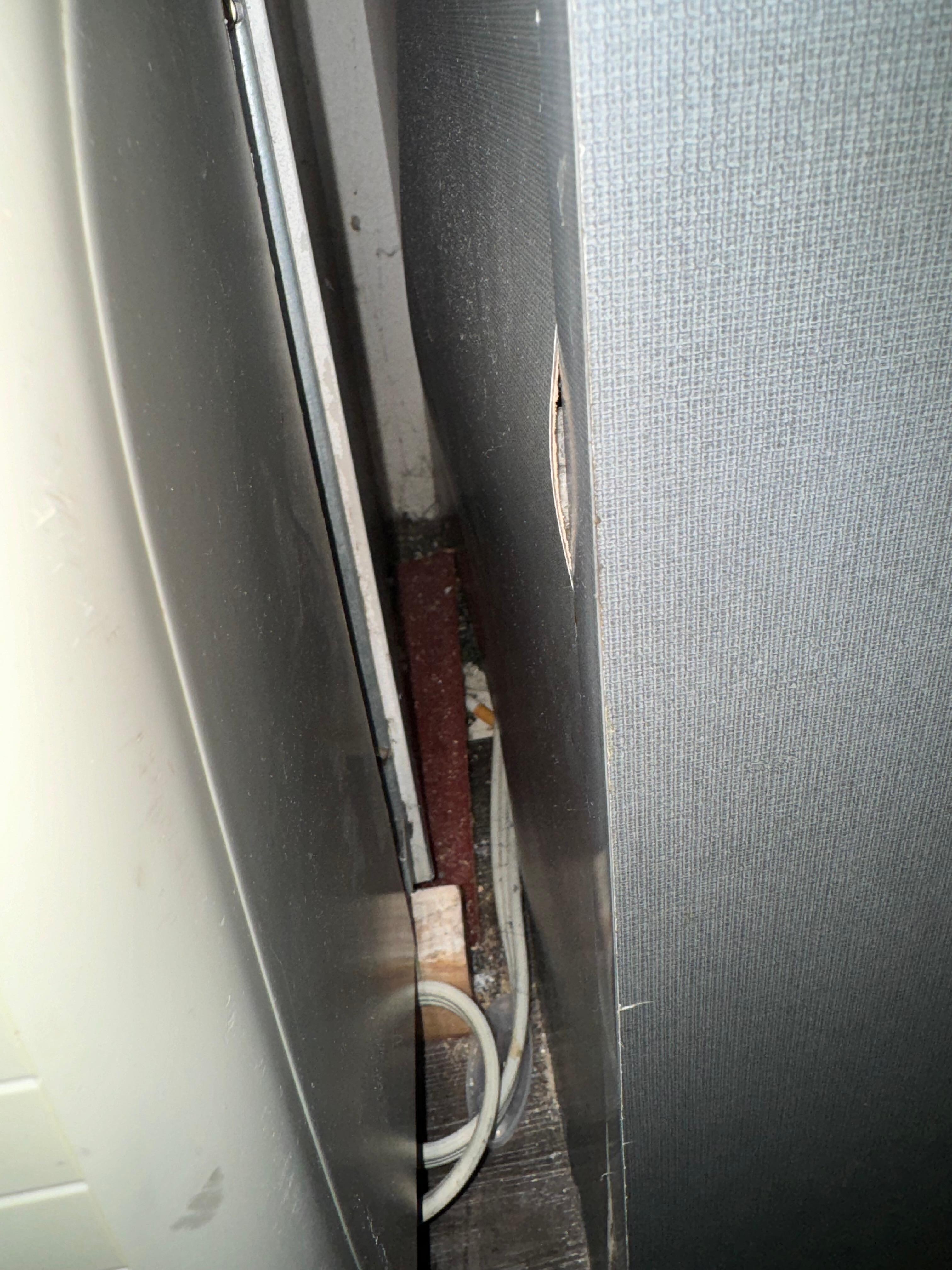 Cigarette butt in between AC/heater unit and built in cabinet