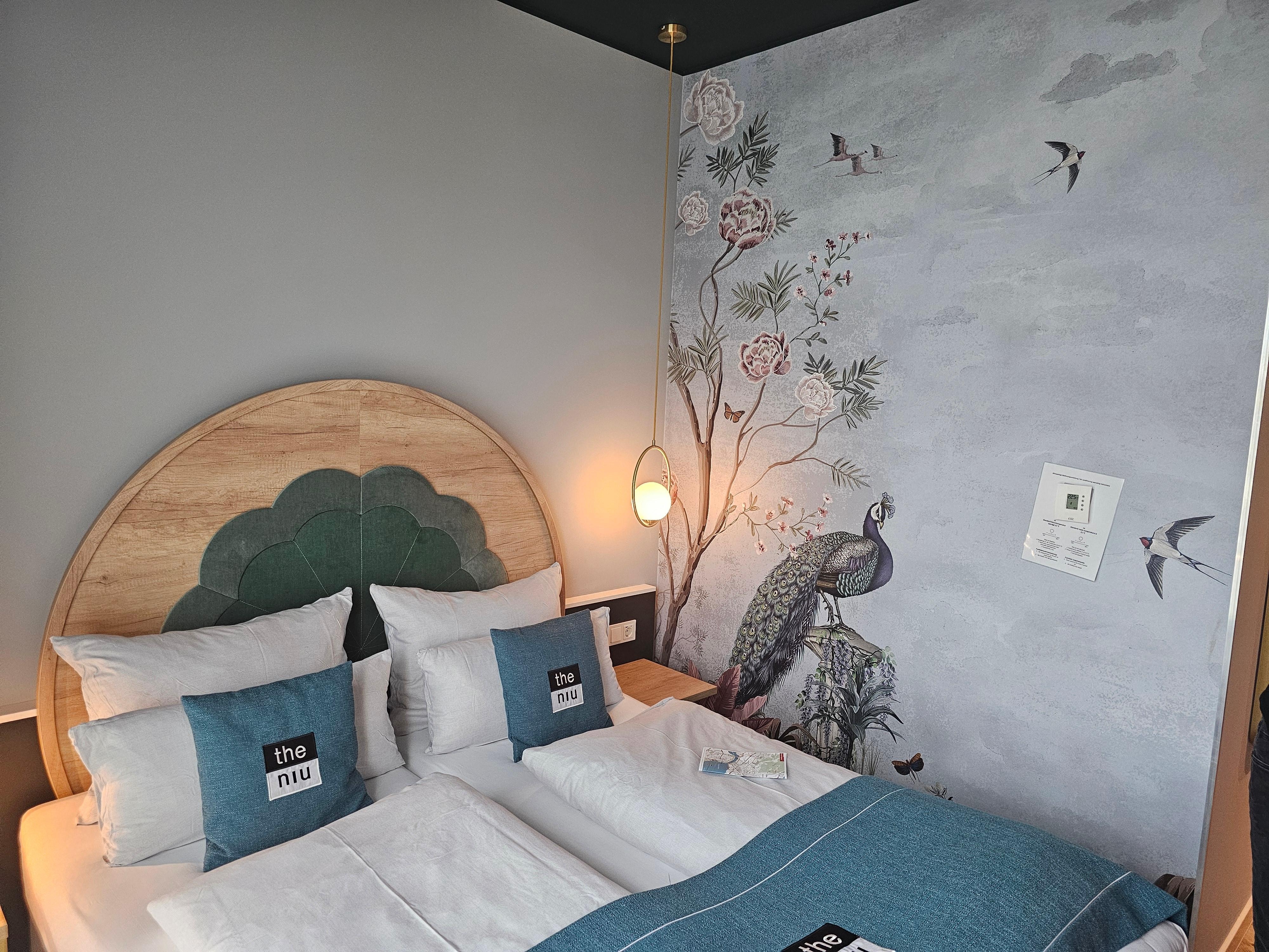 2 zusammengeschobene Betten mit bequemen Matratzen, 2 Nachttischen und Steckdosen.