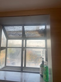 Bathroom window over tub. The top part is all coated on dirt, mold.