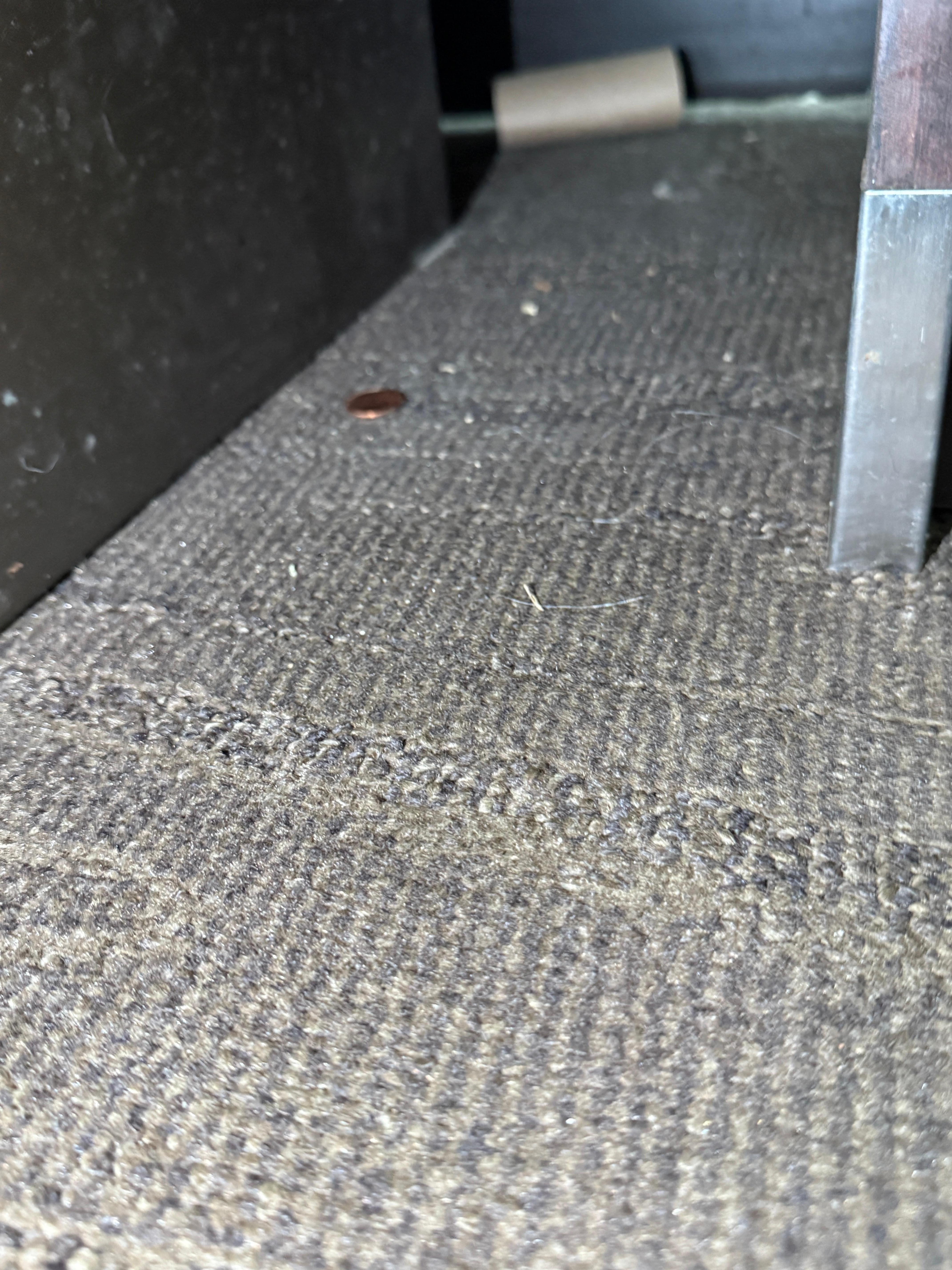 Garbage and dust between bed and nightstand 