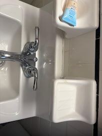 Busted soap holder glued on sink caulking open and towel rack coming off the wall