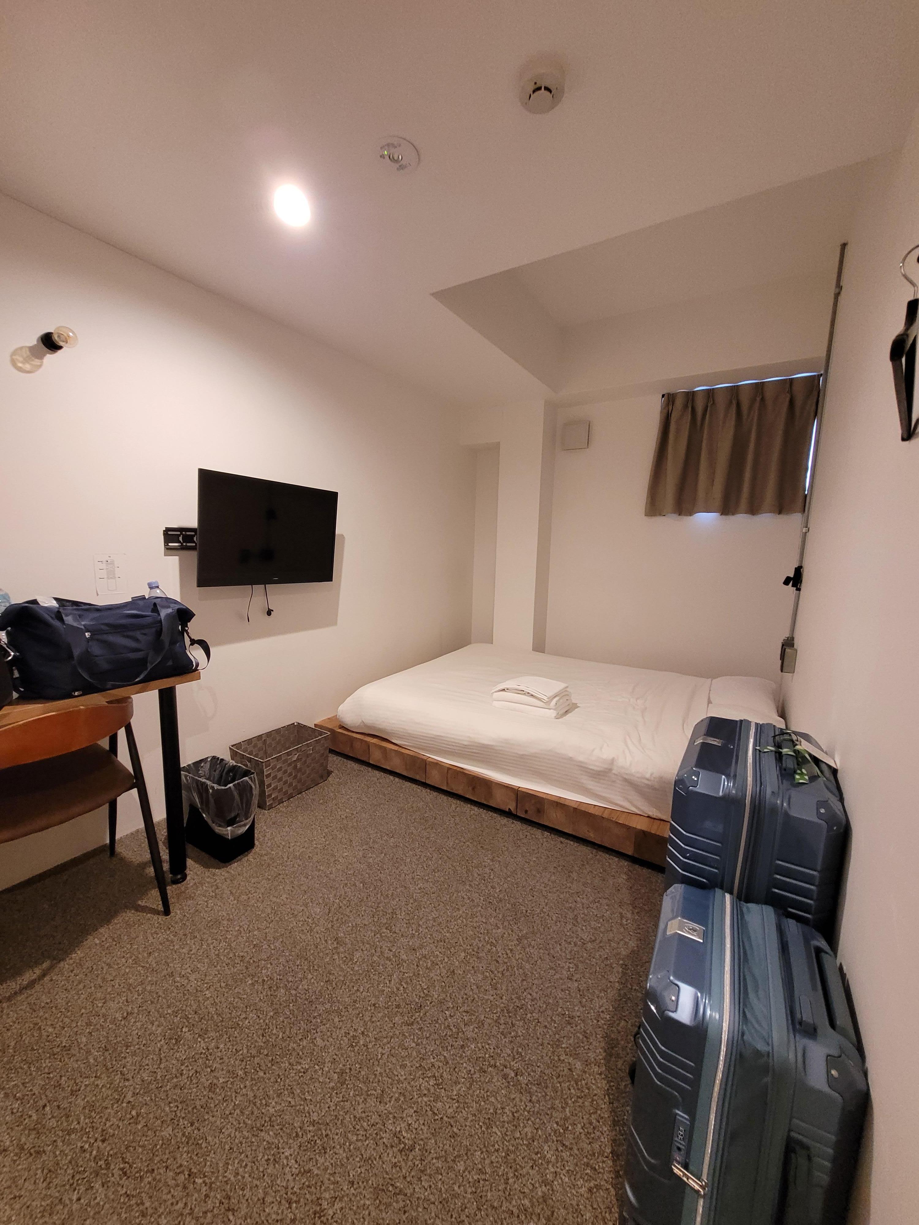 Room with Queen-size bed, small desk and TV