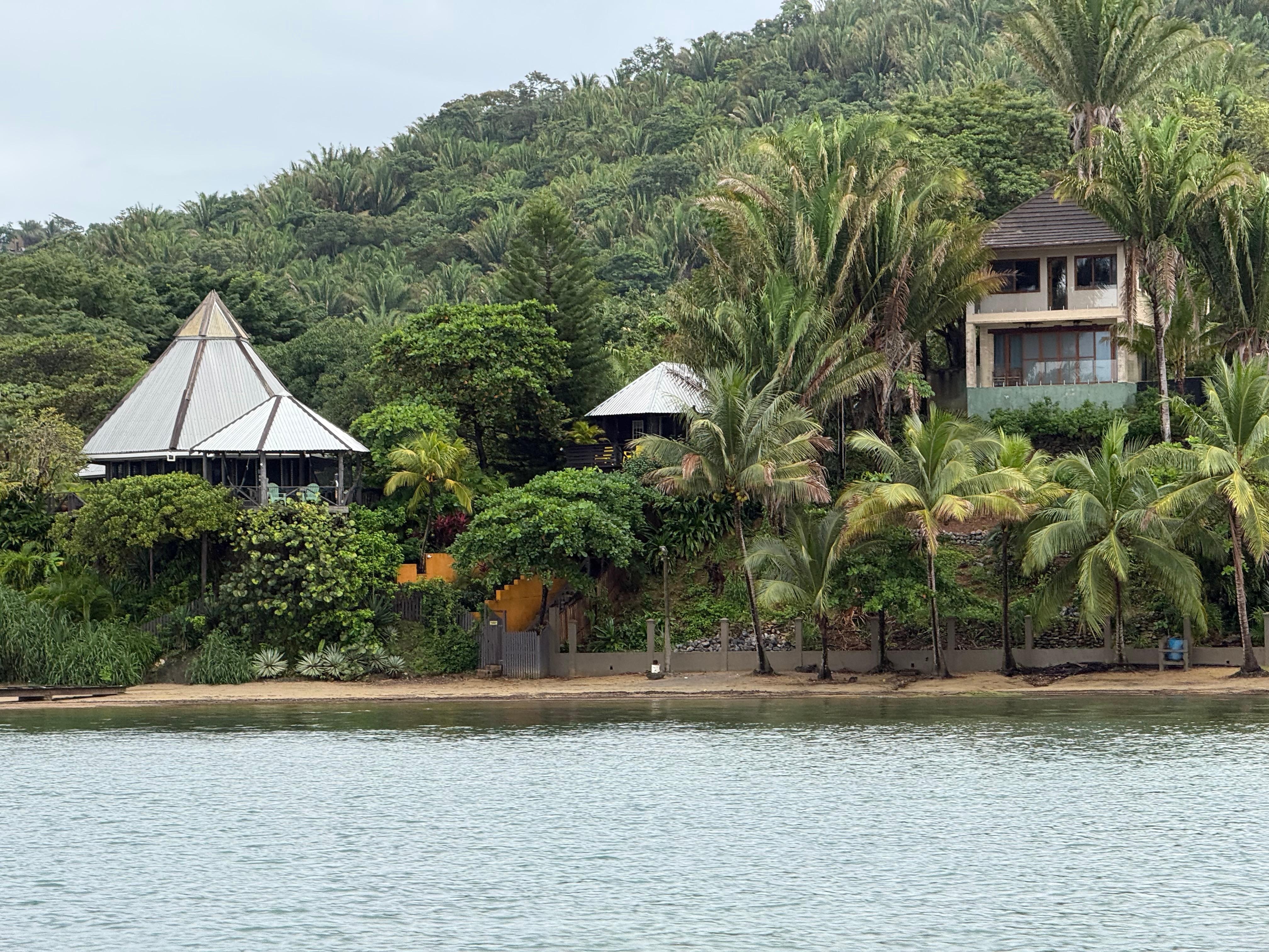 View of the property from the boat. The middle structure is the treehouse and the left larger metal roof is the main house. 