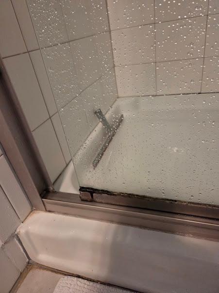 mold on bathroom shower door frame and track and baseboard. 