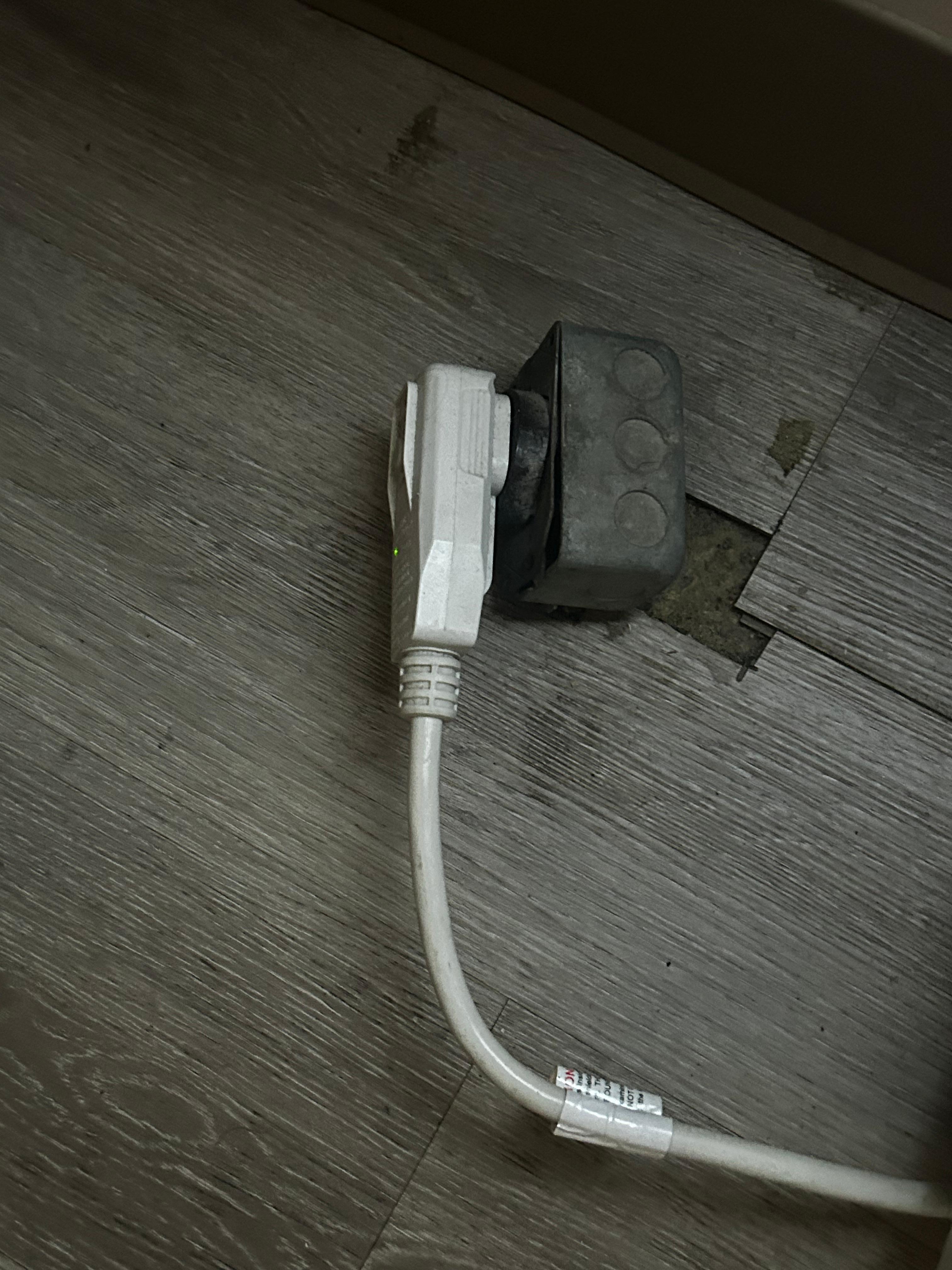Heat pump 220 outlet on floor with plug. Definite fire hazard. 