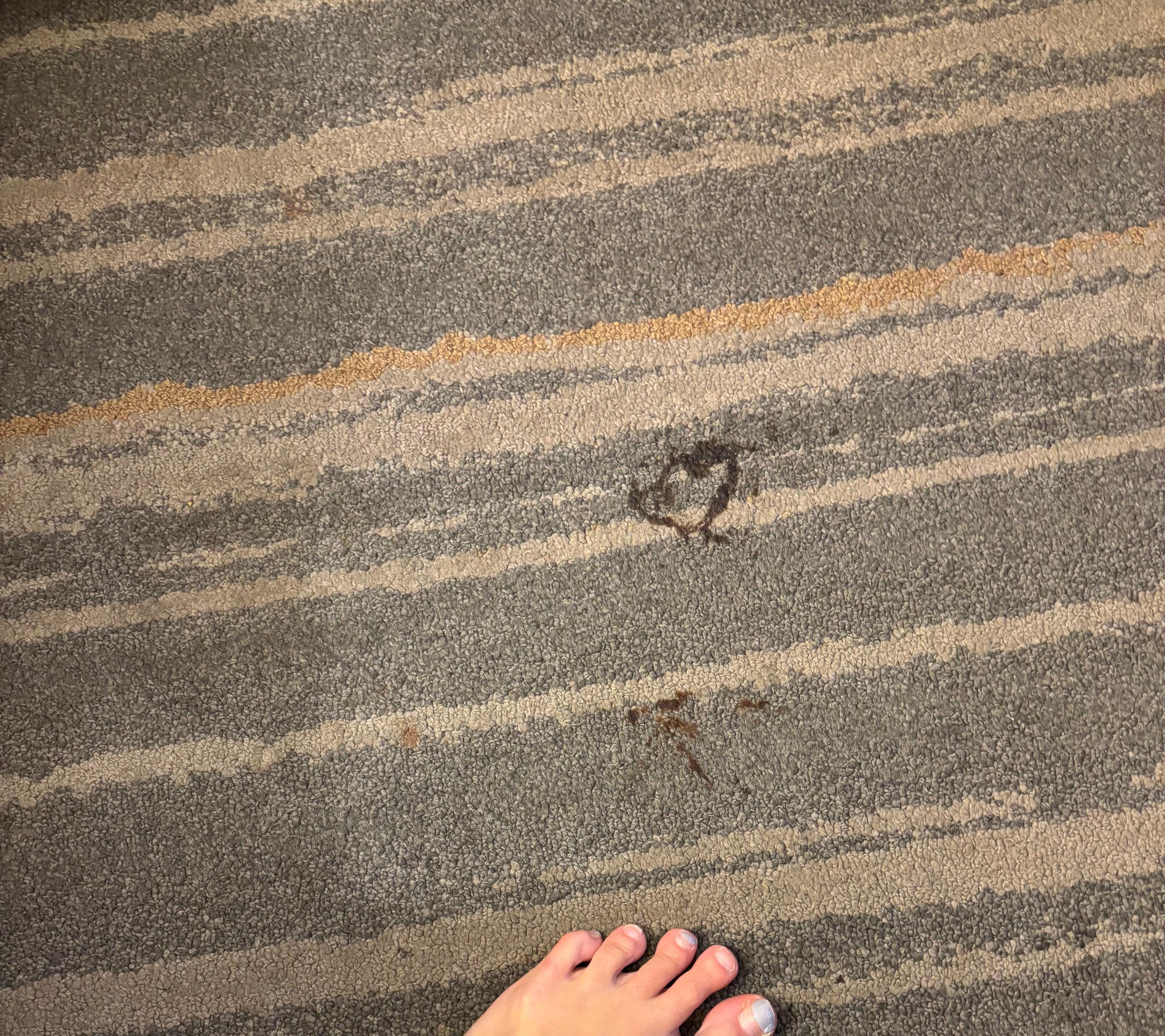 Sticky stain on the floor between the beds