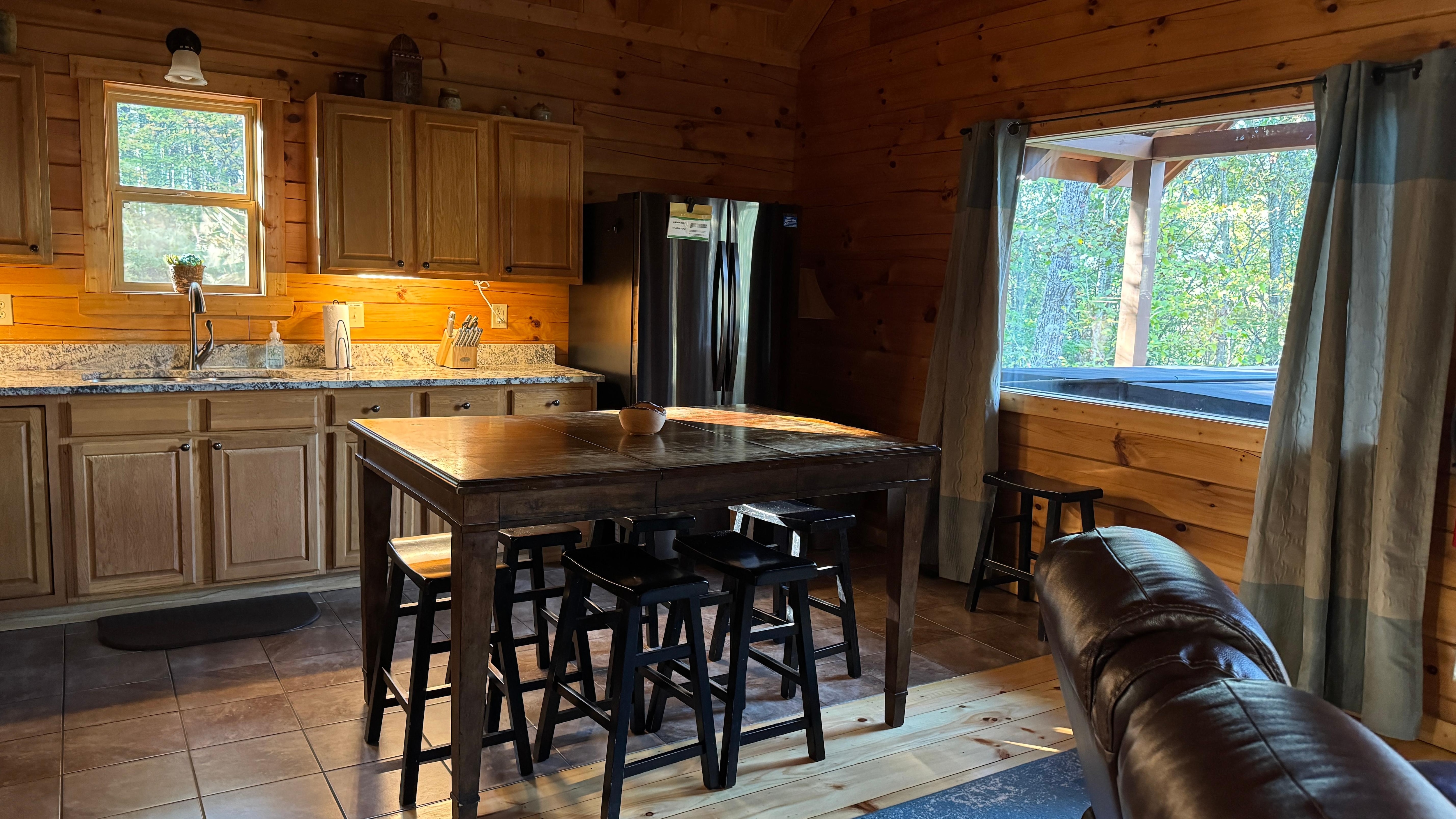 Great layout in kitchen for friends to gather around center table. You can see the jacuzzi just outside the window!