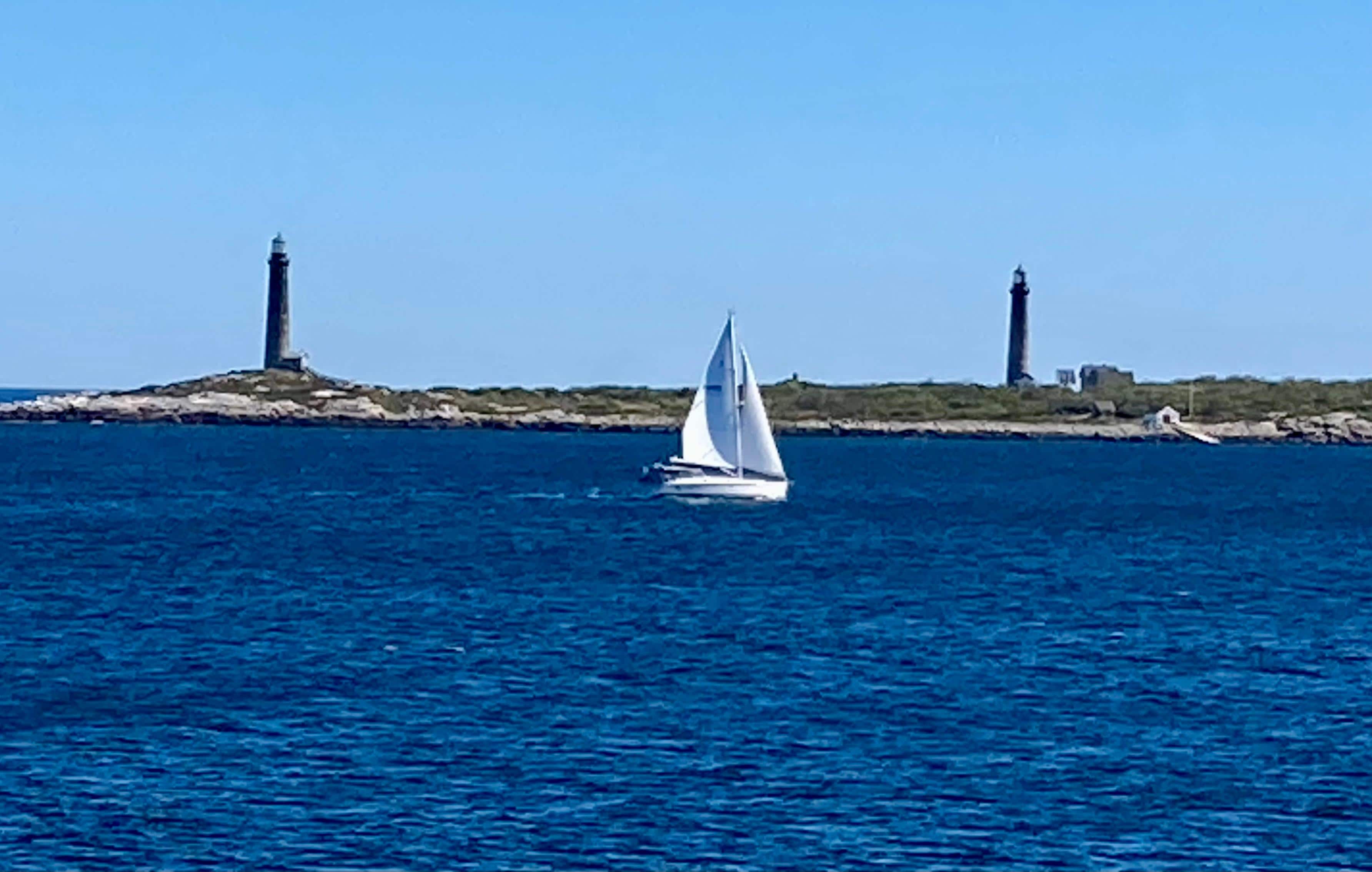 Twin lighthouses with sailboat