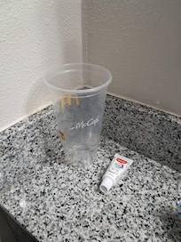 Our small tube of toothpaste beside the cup