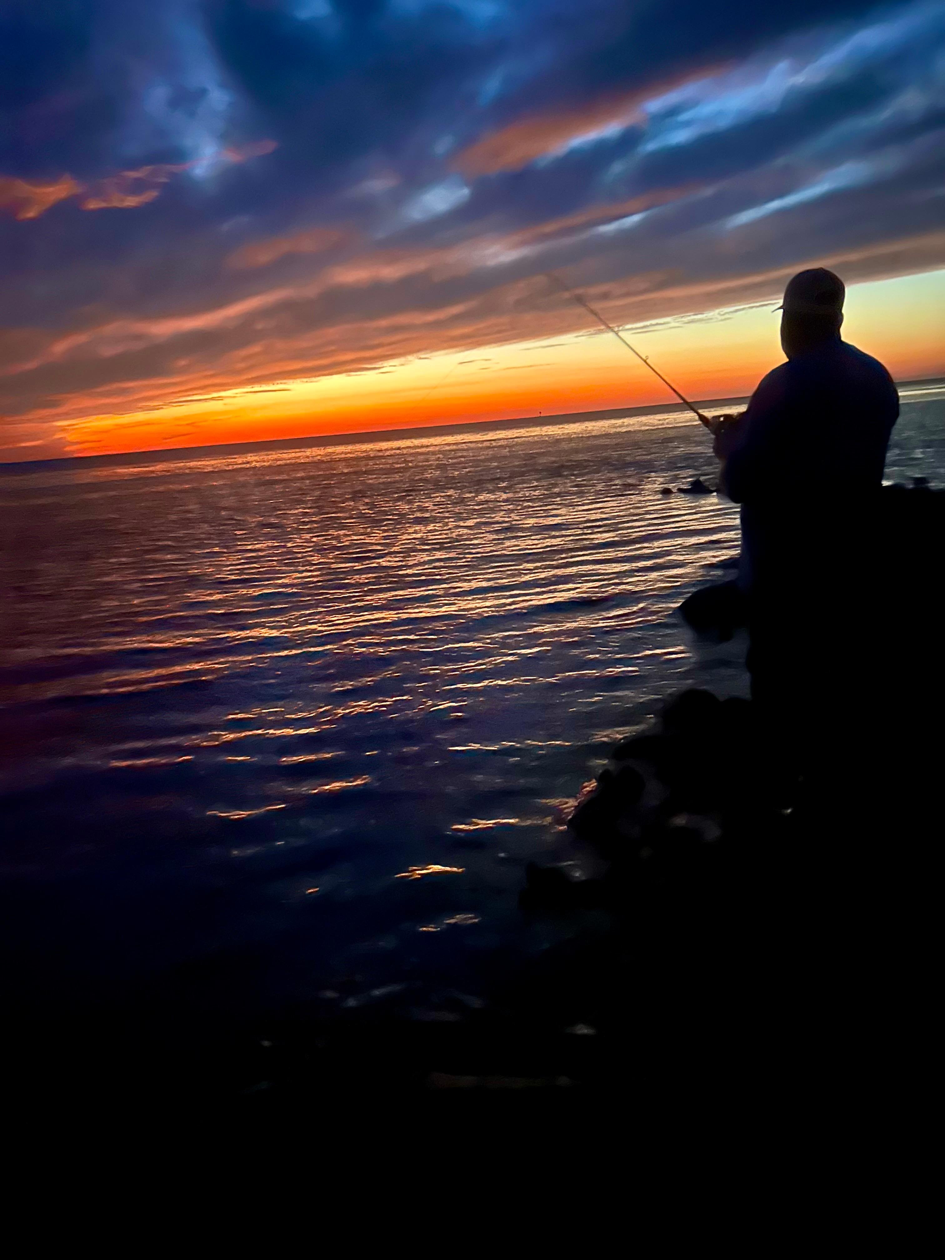 Fishing at sunset at the beach behind the house 