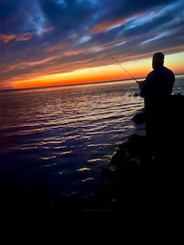 Fishing at sunset at the beach behind the house