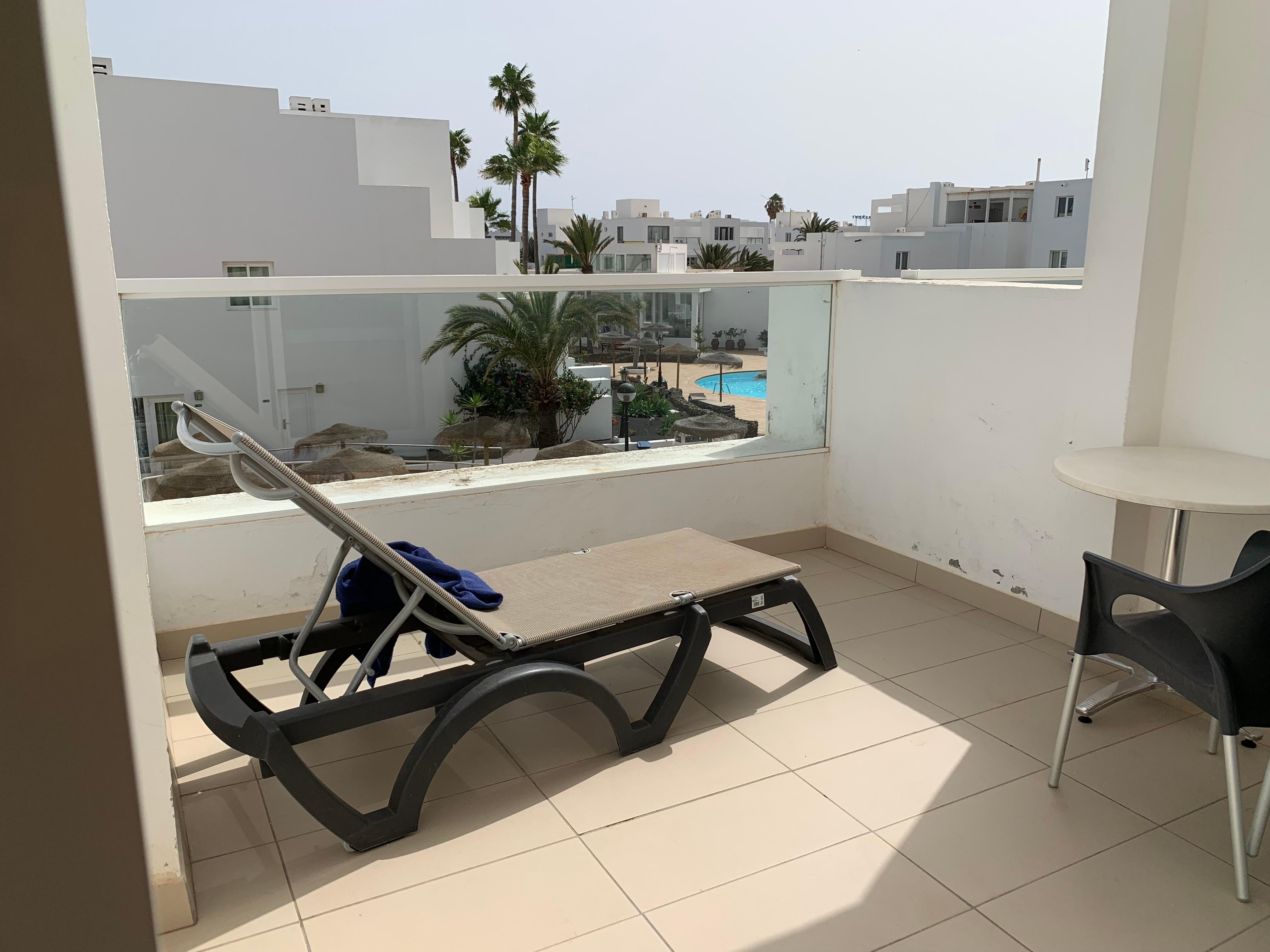 Spacious balcony with a table,4 chairs and a sunlounger