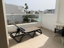 Spacious balcony with a table,4 chairs and a sunlounger