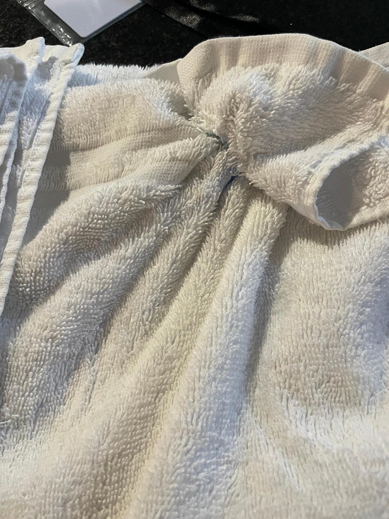 This was supposedly a "clean" towel that was sent the following morning by the cleaners since the towels we received were worn and didn't even match.  Note the blue substance that was stuck in the towel.  It was disgusting!  You couldn't even pull it
