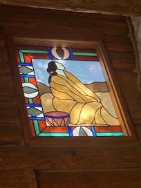 One of the stained-glass windows to one side of the fireplace