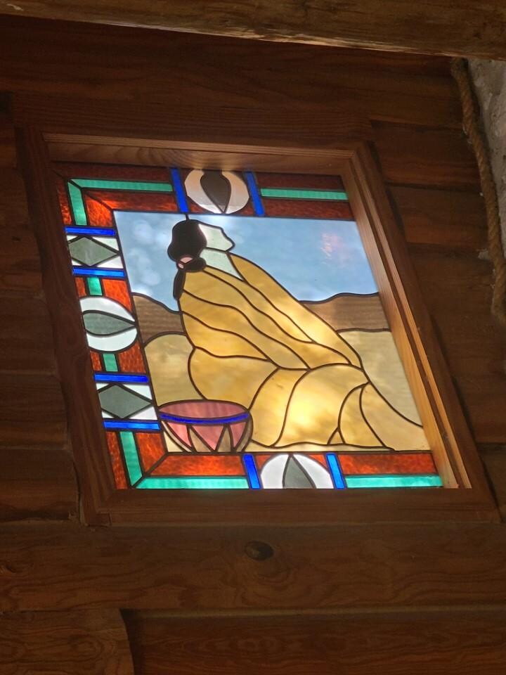 One of the stained-glass windows to one side of the fireplace
