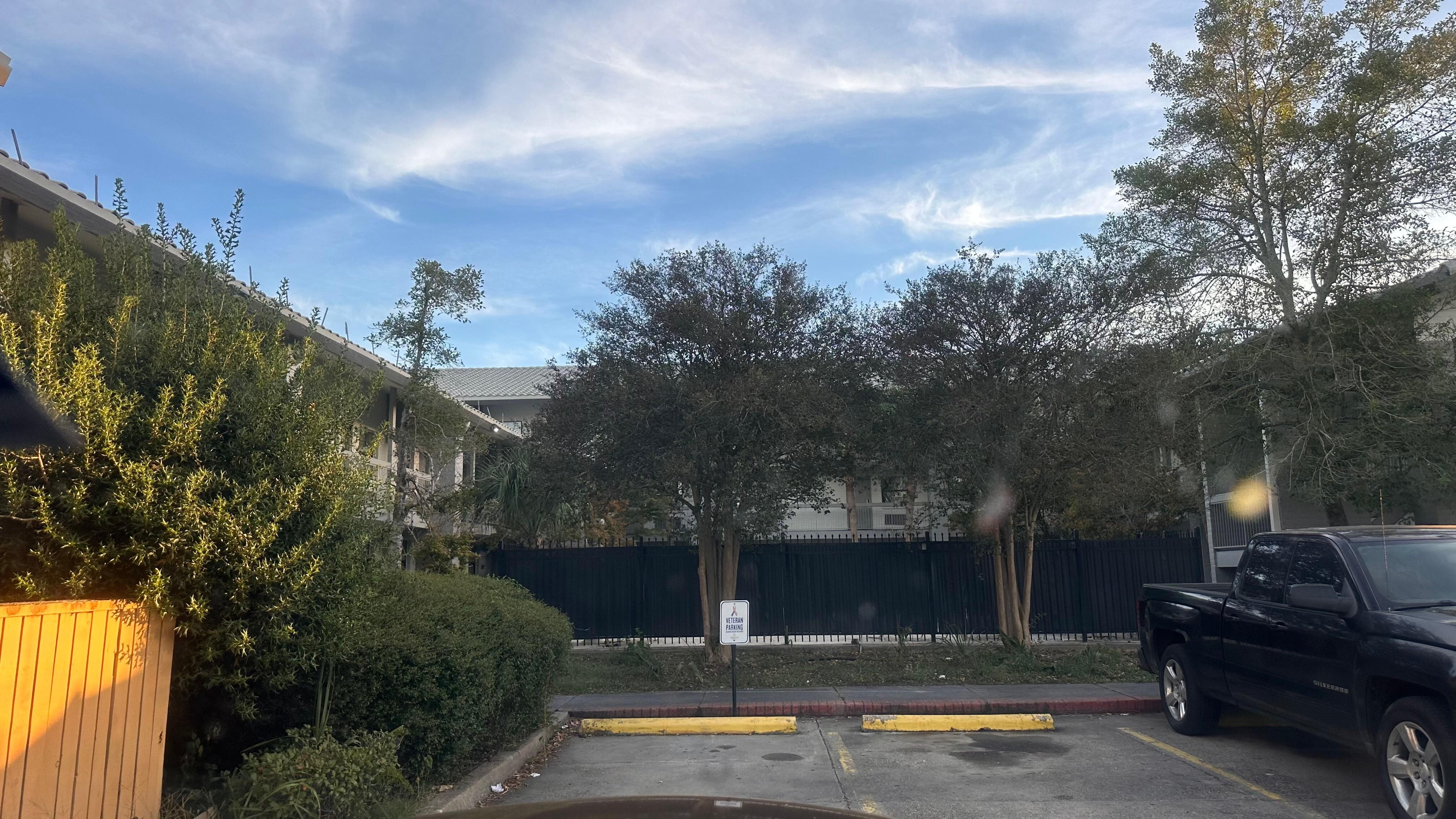 The parking lot has visible cracks, faded paint, and an overall lack of upkeep.