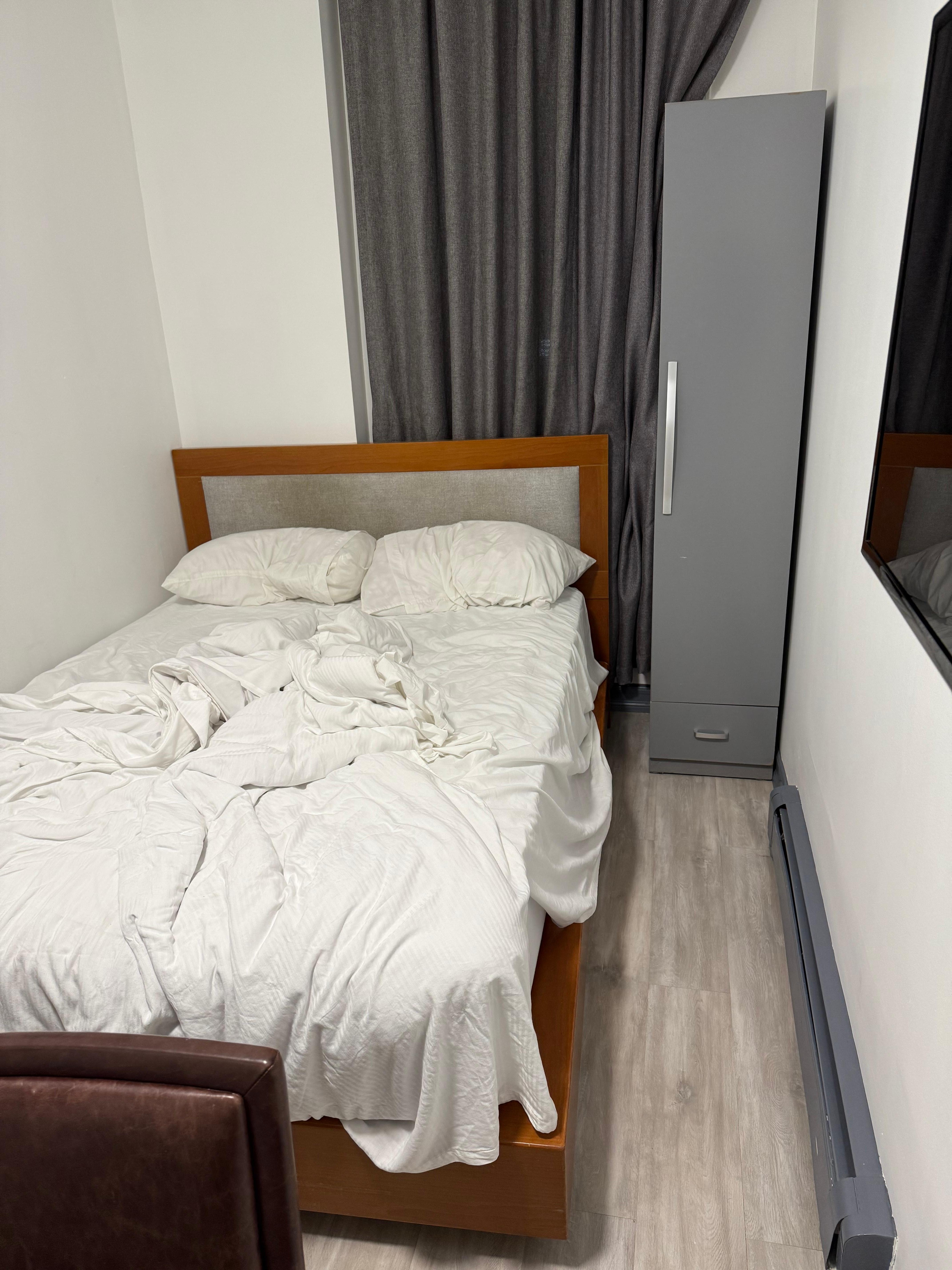 The great cabinet is the only closet and only place to put clothing and partially block the window.