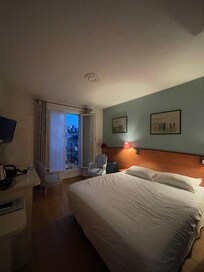 Bedroom plus desk and living space. Two chairs and a closet with safe