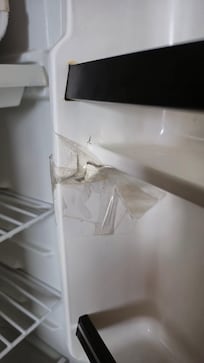 Refrigerator door has a crack, and is fix by tape