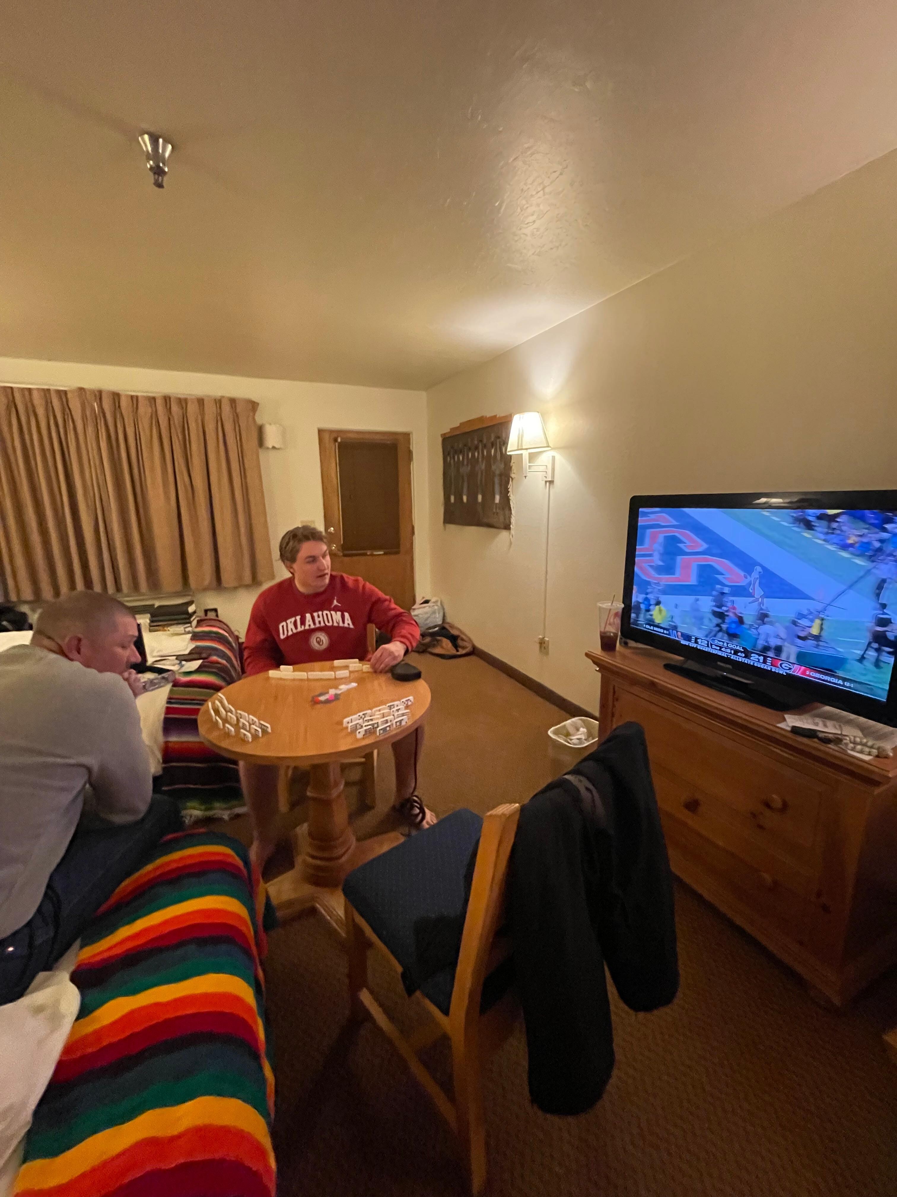 Playing dominos in our room while we watch football after a day on the slopes. 
