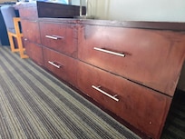 Disgusting grime from years of neglect on drawers and dresser top. Every surface is tacky and gross.