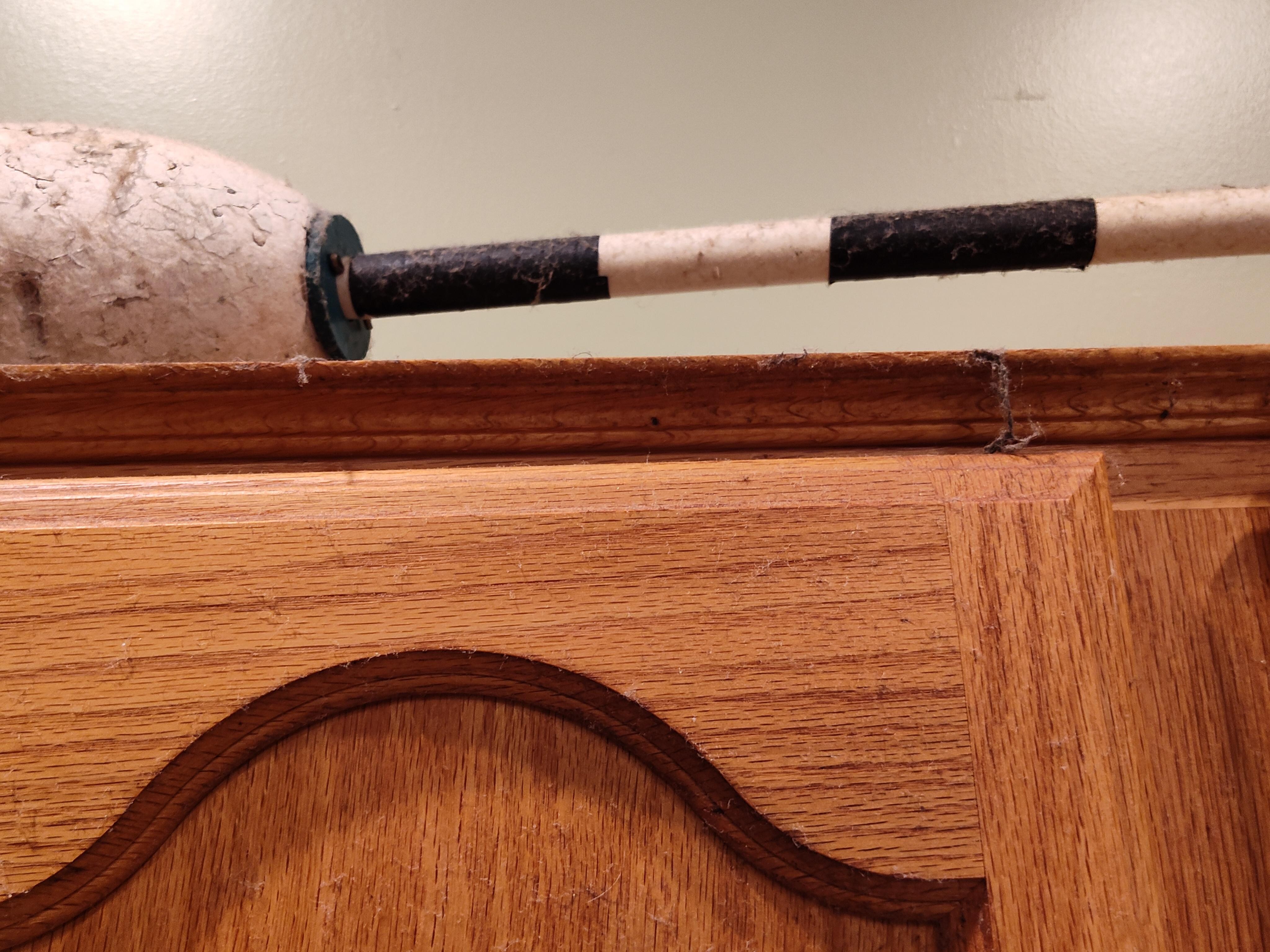 Grease and cobwebs on cabinet tops by stove