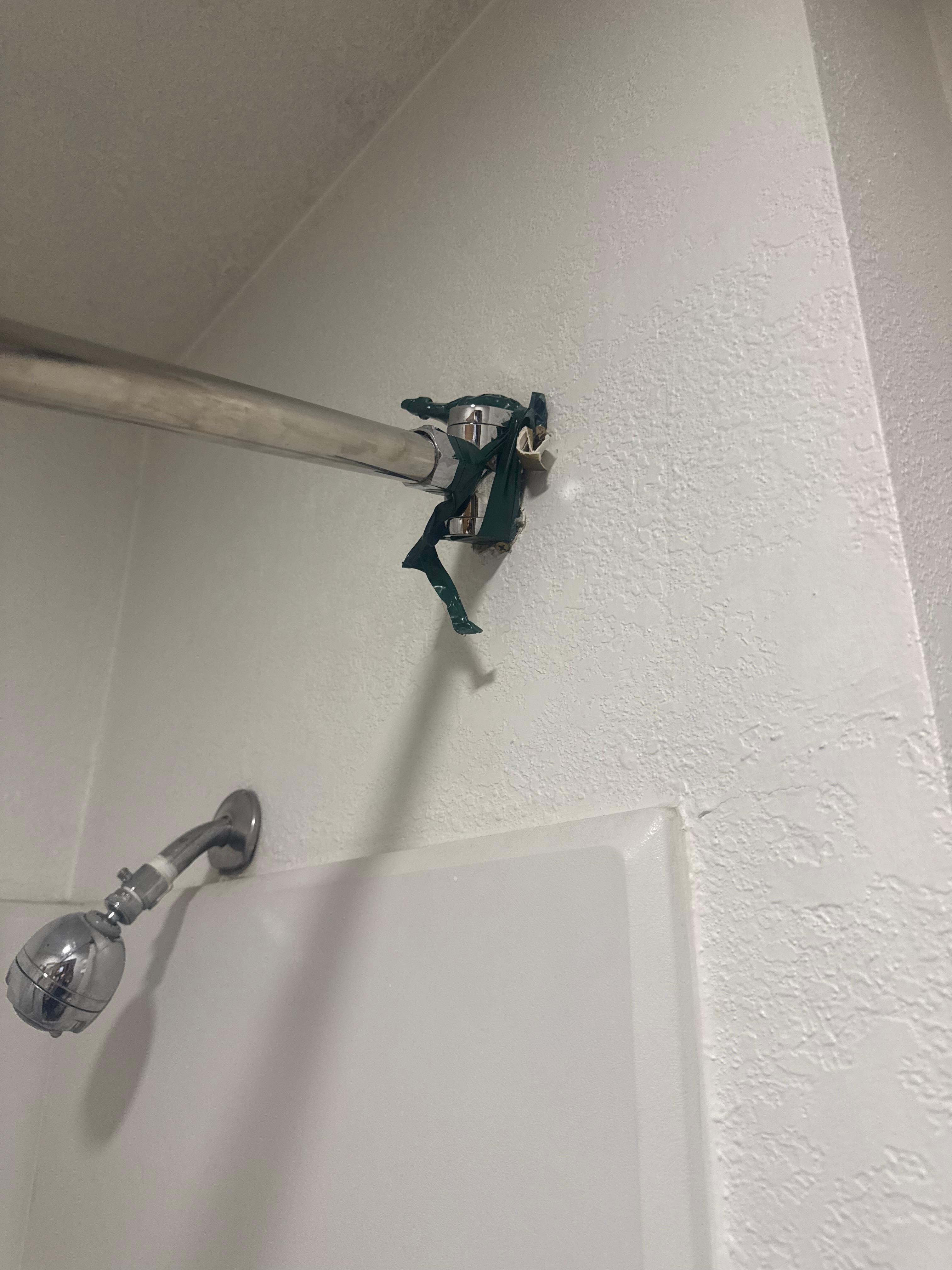 Broken shower rod fixed by tape. 