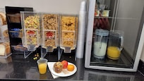 Nice breakfast, cereals, bagels, bread, muffins, juice, milk