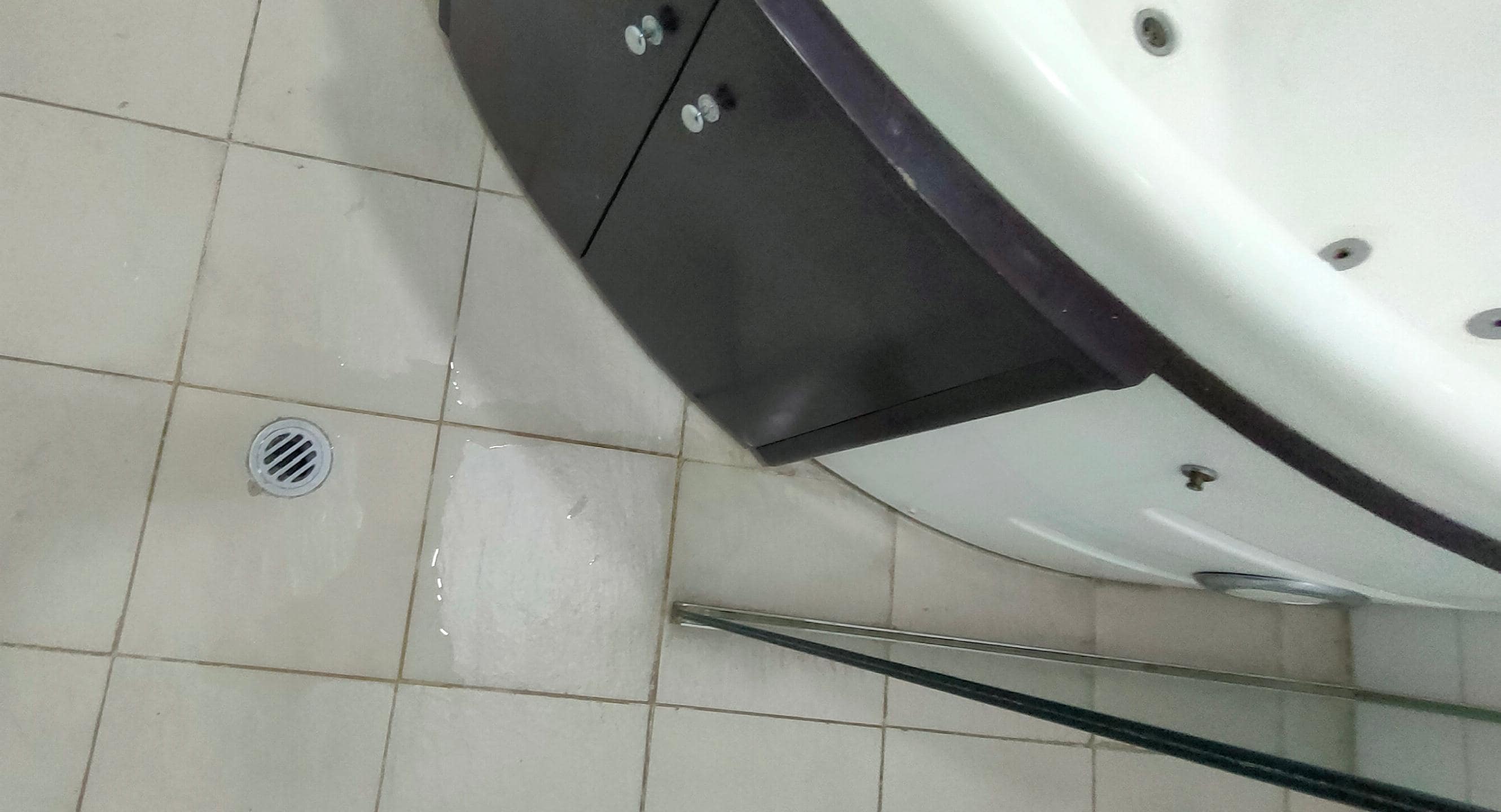 Water coming from under tub