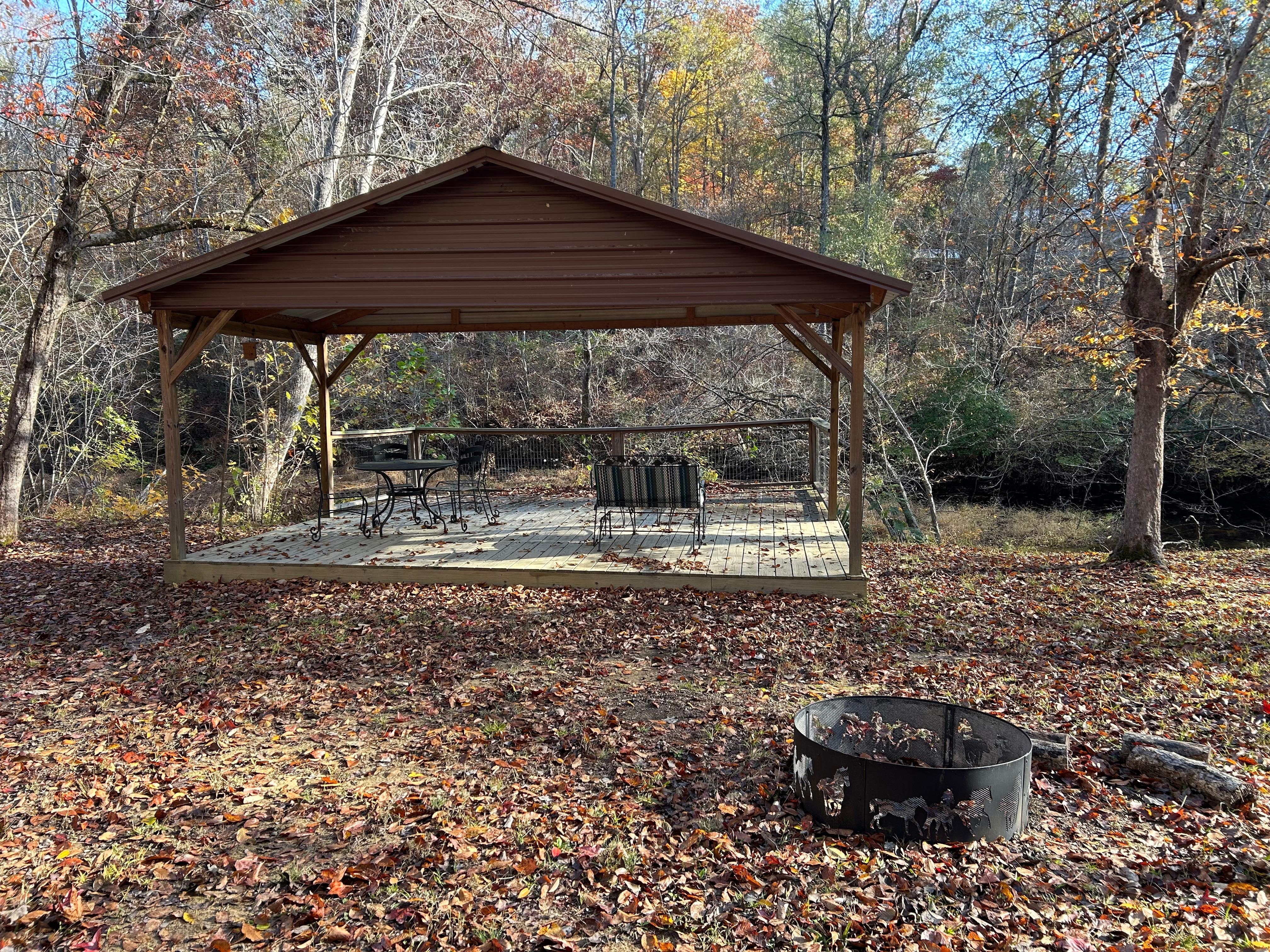 Pavilion with fire pit located on trail below cabin