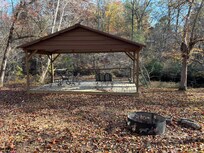 Pavilion with fire pit located on trail below cabin