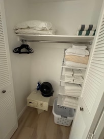 Primary bedroom closet with safe and a few hangers.