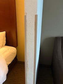 Wall between bed w/ stain and couch