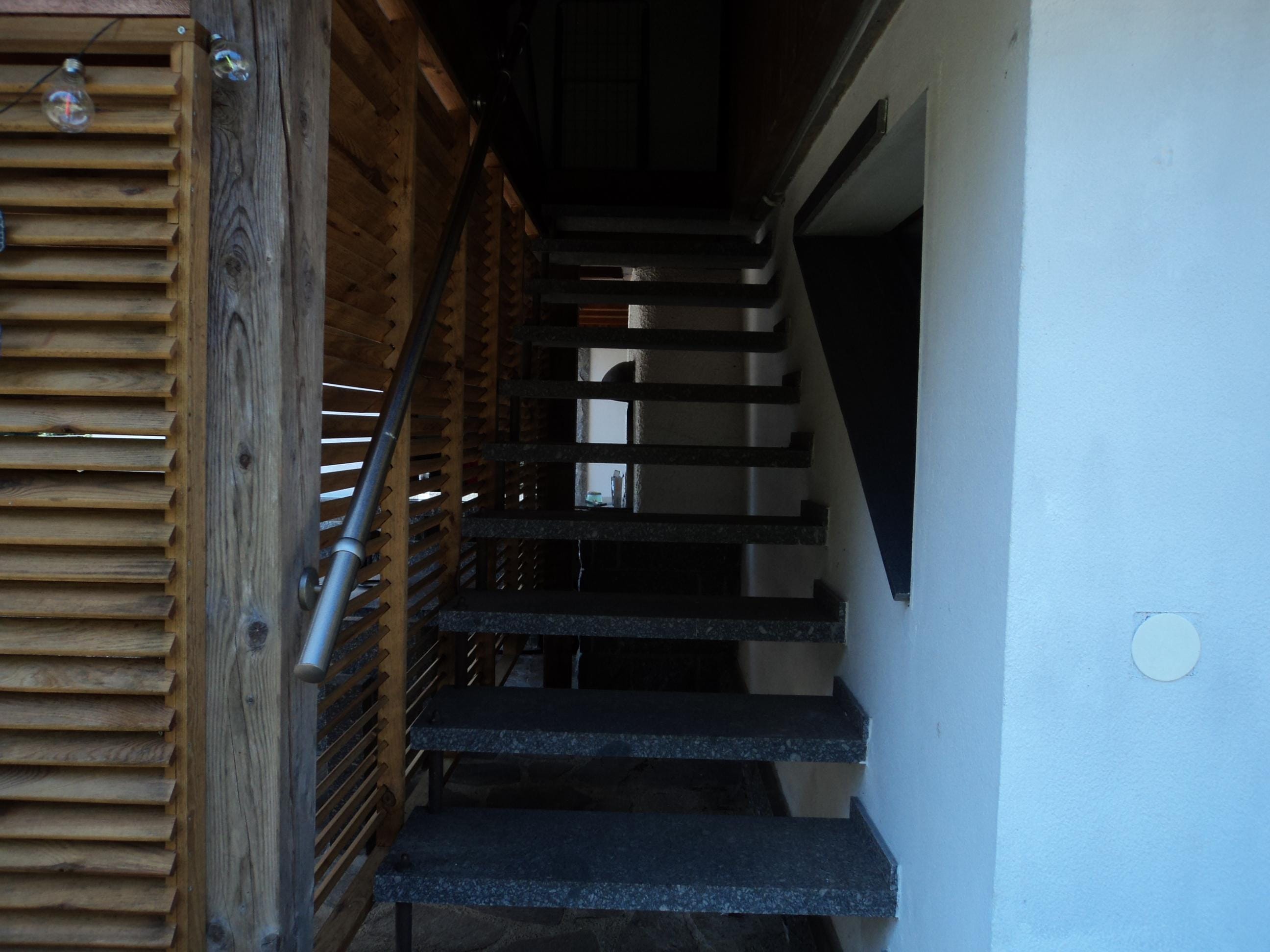 escalier qui donne au gite et dessous l'escalier le barbecue de l'autre gite
