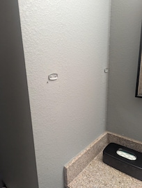 Very unprofessional, remove old brackets and patch wall.