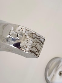 Brown stuff on faucet in tub