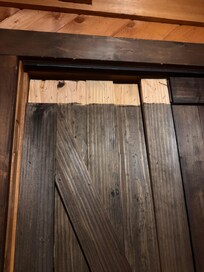Damaged closet doors with nails sticking out of the wood