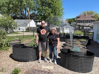 Christine Coy and son Robert White in the backyard garden.
