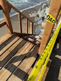 Stairs are dangling from the back of the patio.