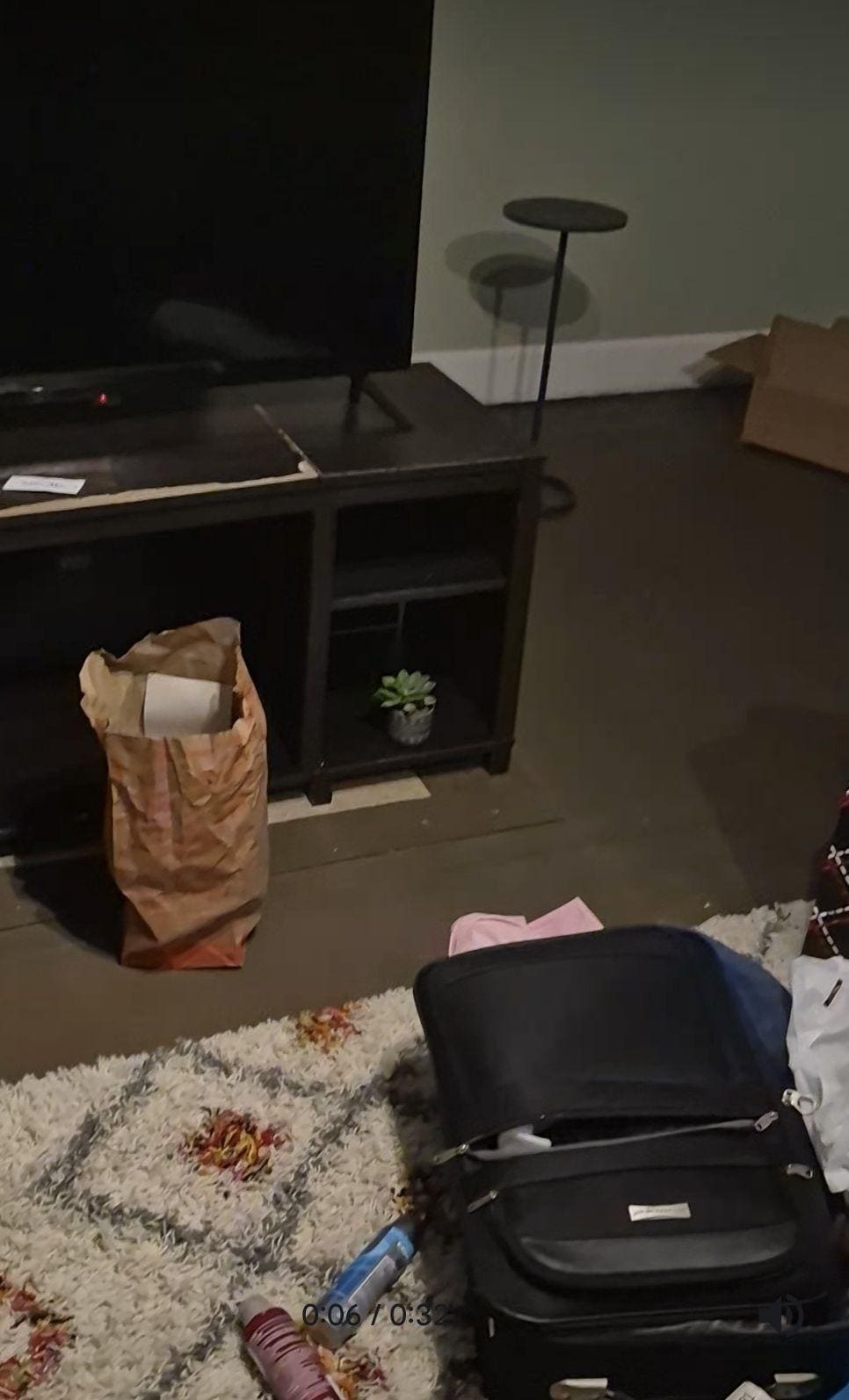 Fast food bags and dirty clothes on floor and surfaces of living room