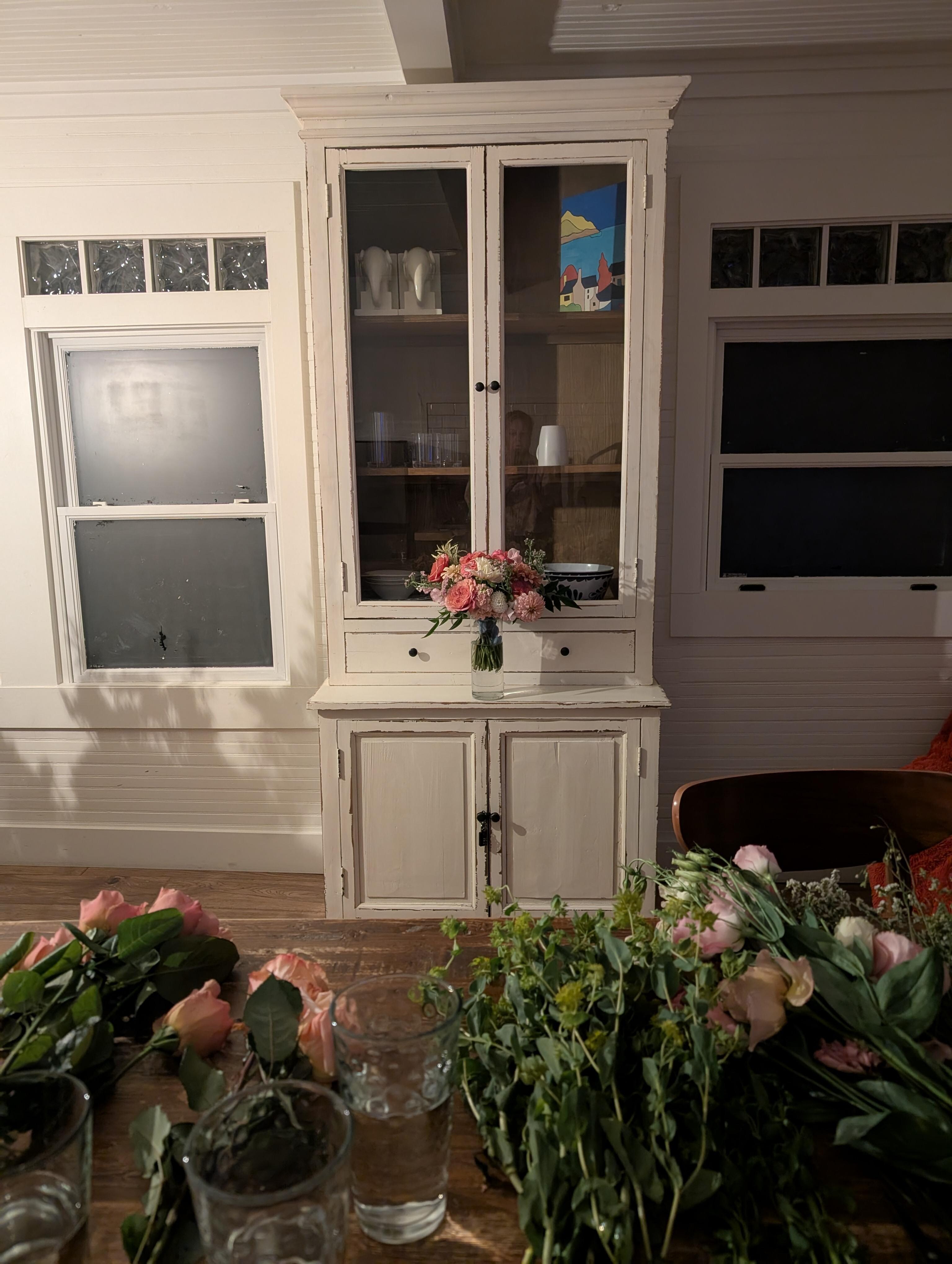 looking at the cupboard from the sink. there are modern amenities opposite the photo