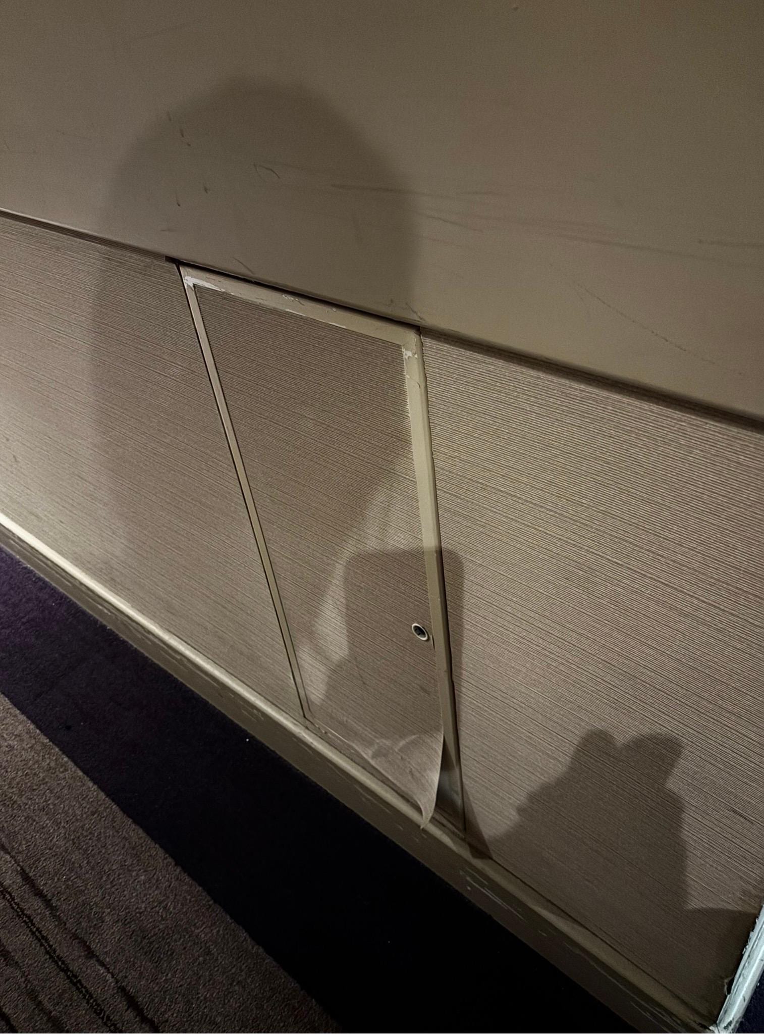 Panel peeling on corridor wall.